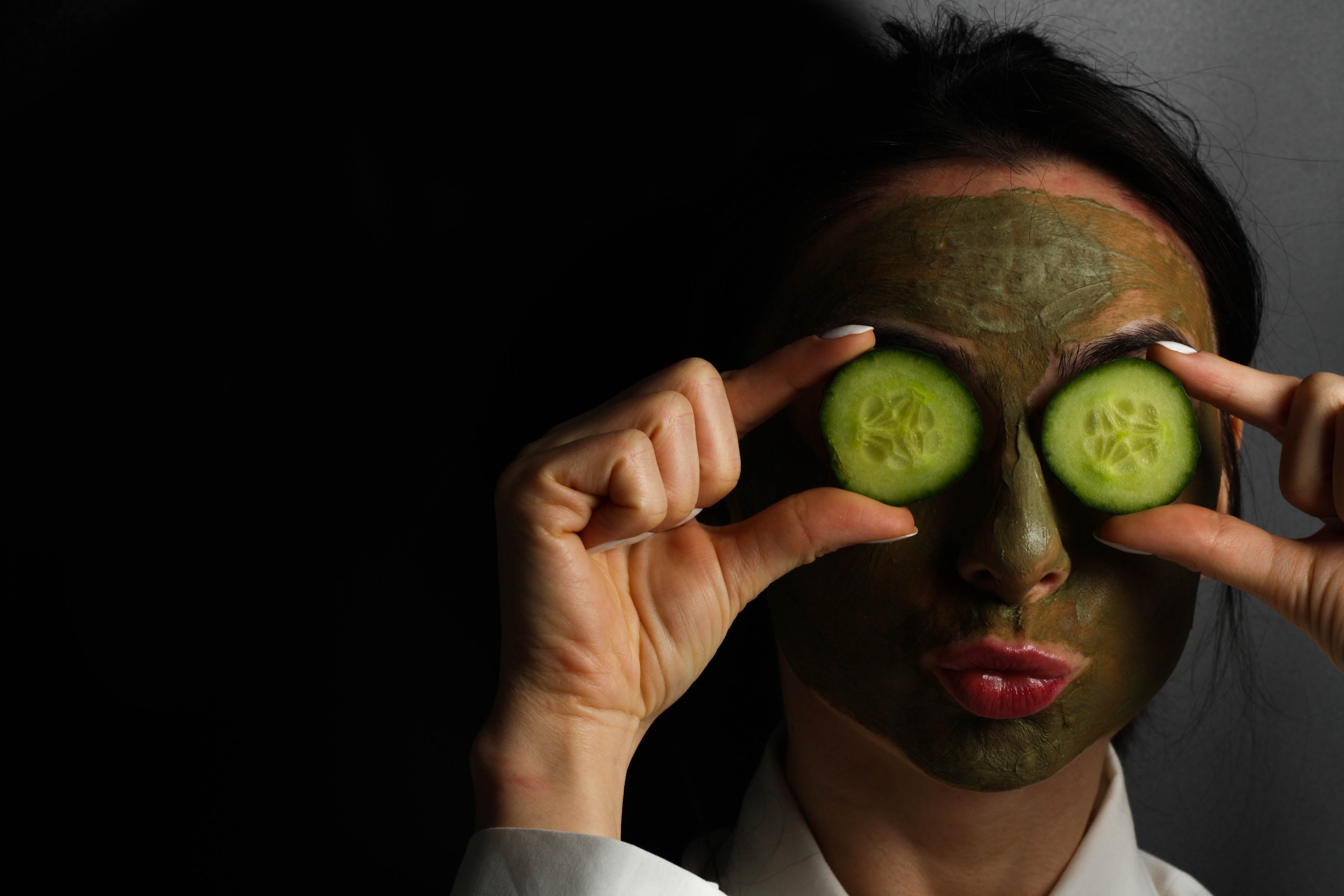 Women smiling with facial mask and cucumber slices